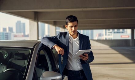 Person holding car keys with an insurance document, representing non-owner car insurance coverage