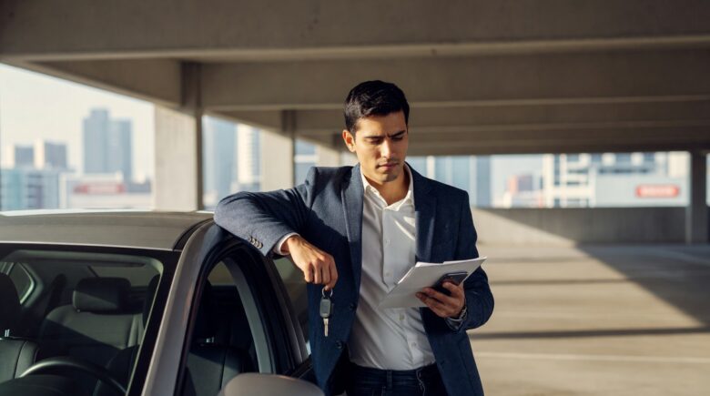 Person holding car keys with an insurance document, representing non-owner car insurance coverage
